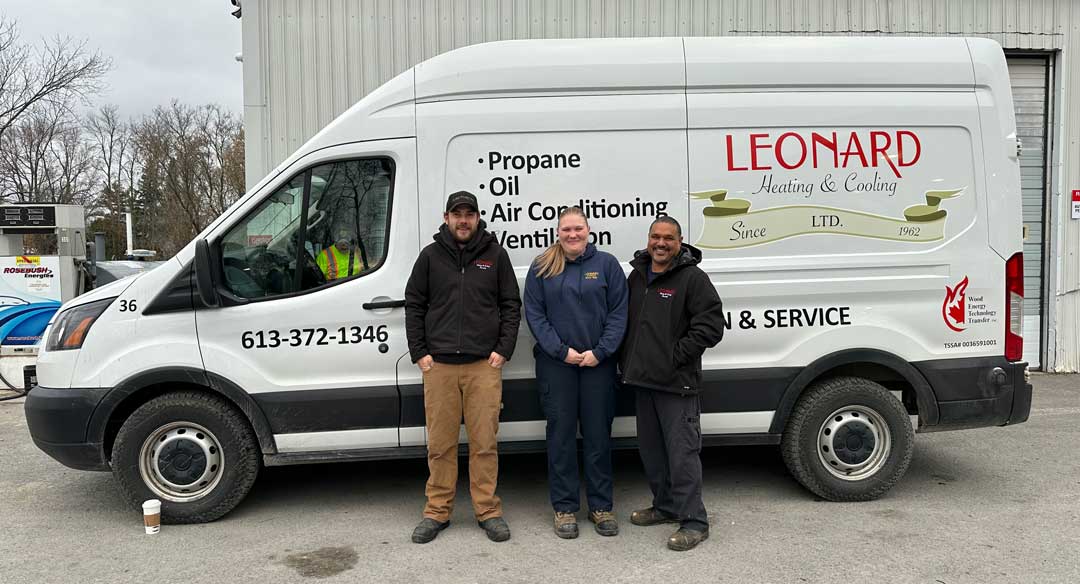 Leonard Heating team members James, Tabby and Ray stand in front of a Leonard Heating van.